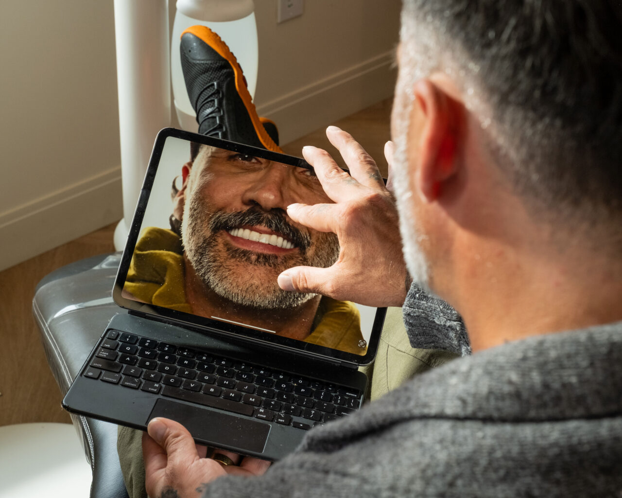 'http://A%20man%20sits%20in%20a%20dentist's%20chair,%20smiling%20and%20touching%20a%20tablet%20screen%20that%20shows%20his%20reflection%20with%20a%20bright%20smile,%20highlighting%20his%20teeth.