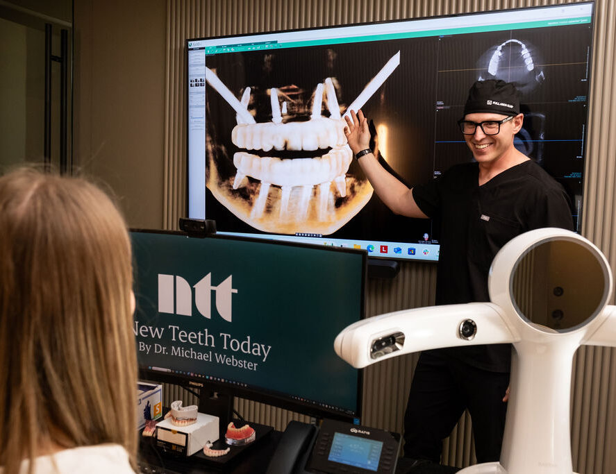 'http://A%20dentist%20in%20black%20scrubs%20and%20glasses%20points%20at%20a%20large%20dental%20X-ray%20on%20a%20screen%20while%20smiling%20and%20explaining%20to%20a%20seated%20patient.%20Dental%20equipment%20and%20a%20monitor%20displaying%20New%20Teeth%20Today%20are%20visible%20in%20the%20foreground.